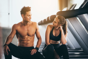 Naklejka na ściany i meble Fitness couple - woman and man in sport gym