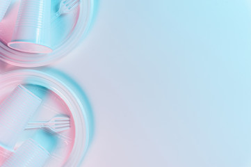 Disposable plastic tableware on a light background in pastel colors. Minimalistic ecologically clean still life. Pop Art. And ecology problem concept.