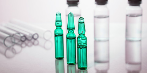Group of vials with medication on blue methacrylate table.