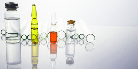 Group of vials with medication on blue methacrylate table.