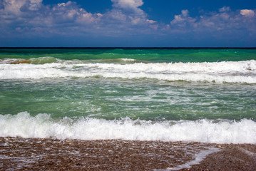 Beautiful landscape/seascape of green ocean and blue cloudy sky in summertime on the beach. Ocean, sea, vacation and summer concept.