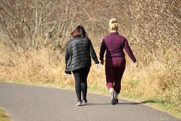 Adult women taking a walk in a park on a sunny day.