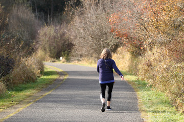 Adult woman taking a walk in a park on a sunny day.