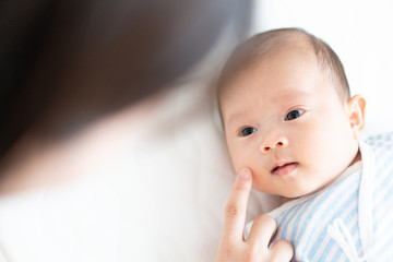 赤ちゃんの顔に触れる女性