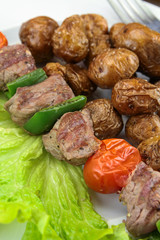 grilled potatoes and beef skewer on a plate