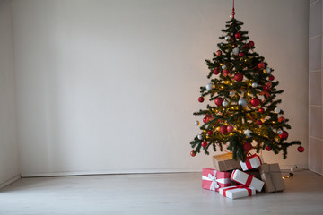Christmas tree with gifts in the interior of the white room decor for the new year
