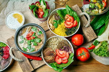 Composition with a dinner table with vegetarian dishes: bowl, dessert and miso soup on a gray cloth. Healthy and balanced food. Menu photo, top view