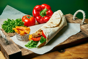 Vegetarian shawarma roll in pita with lettuce, vegetables, and pumpkin. Tasty, wholesome and green food. Vegan street food