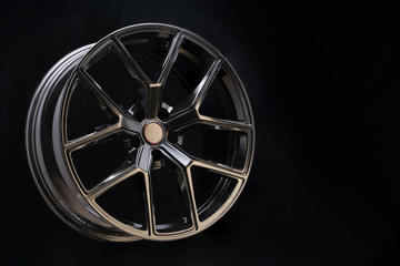 beautiful and cool aluminum forged wheel, close-up. dark on black background, copyspace. sports style for auto racing and auto tuning, lightweight and durable.