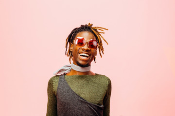 Portrait of a happy and cheerful young man laughing, isolated on pink