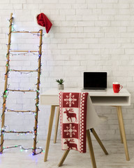 Santa's workplace with black modern laptop and ladder