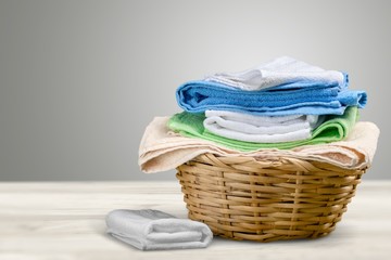 Laundry Basket with colorful towels on background