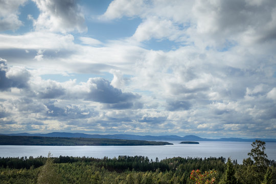 Beautiful autumn cloudscape view of lake Siljan in Dalarna Sweden. Forest, water and land in the foreground.