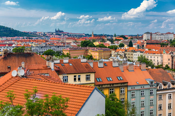 Naklejka premium View of Prague Castle over red roof from Vysehrad area at sunset lights, Prague, Czech Republic. Scenic view of Prague city, Prague castle and Petrin tower from Vysehrad overlooking red roofs