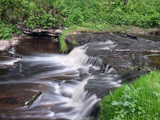 landscape with small waterfall (cascade) on river with motion blur. 