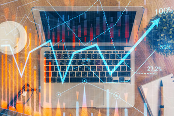 Double exposure of graph and financial info and work space with computer background. Concept of international online trading.
