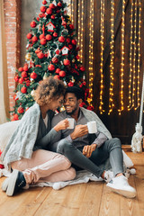 Obraz premium Young couple drinking coffee and enjoying Christmas morning