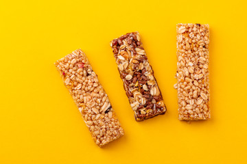 Top view on three granola bars on yellow background