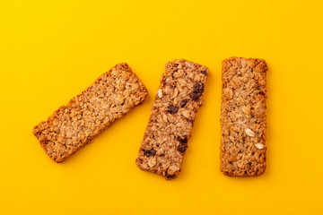 Top view on three granola bars on yellow background