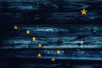 Alaska State flag on weathered wooden wall