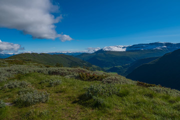 Through the Vikafjell a pass road to Vik is located in the kommunes Hordaland and Sogne og Fjordane. Mountains with summer snow on background. July 2019