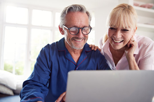 Mature Couple At Home Looking Up Information About Medication Online Using Laptop