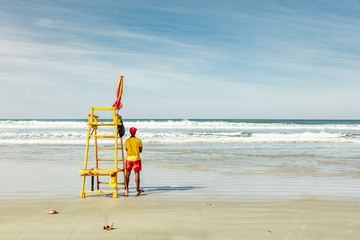 Lifeguards on the beach, saving the lives of sunbathers who can drown in the sea in July vacation...