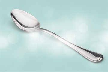 Silver spoon on vintage background in the glare of the sun