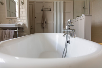 Luxury bathroom interior with classic rolltop bath tub and vintage tap