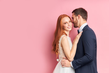 Gorgeous two people get married, woman with red hair, bearded man stand hugging each other, happ...