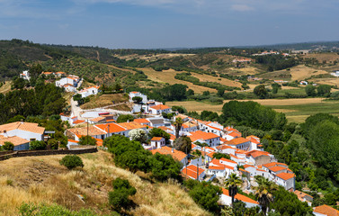 Fototapeta na wymiar Charming architecture of hilly Aljezur, Algarve, Portugal. View to the small town of Aljezur with traditional portuguese houses and rural landscape, Algarve, Portugal.