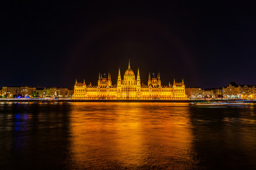 Fototapeta na wymiar Illuminated historical building of Hungarian Parliament at night on Danube River Embankment
