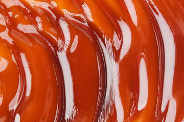 The texture of the wavy caramel closeup. View from above. Spreading caramel.