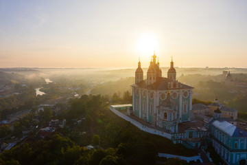 Aerial view of Uspenskiy Cathedral in Smolensk, Early summer morning and fog over the city in the rays of the rising sun.