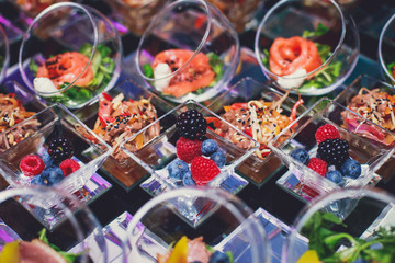 Beautifully decorated catering banquet table with different food snacks and appetizers on corporate christmas birthday party event or wedding celebration, different vegan vegetarian snacks