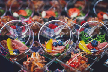 Beautifully decorated catering banquet table with different food snacks and appetizers on corporate christmas birthday party event or wedding celebration, different vegan vegetarian snacks