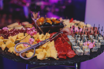 Beautifully decorated catering banquet table with different food snacks and appetizers on corporate christmas birthday party event or wedding celebration, different vegan vegetarian snacks