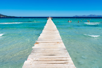 wooden pier on the shore of the Mediterranean sea in Alcudia in Mallorca