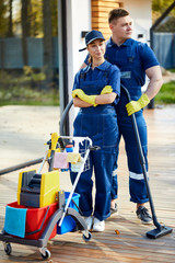 Portrait of young caucasian staff from cleaning service stand with detergents, cleaning equipment....