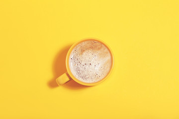 Cup of coffee on yellow background. Minimalism concept