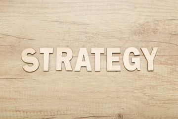 Word Strategy by wooden letters on brown table