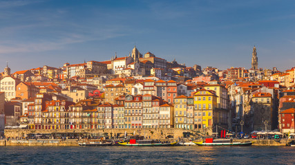 Obraz premium Kolorowe domy Porto Ribeira, tradycyjne fasady, stare wielokolorowe domy z czerwonymi dachówkami na nasypie w mieście Porto, Portugalia