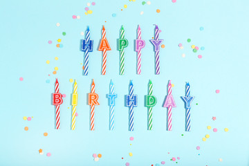 Candles with text Happy Birthday on blue background. Minimalism concept