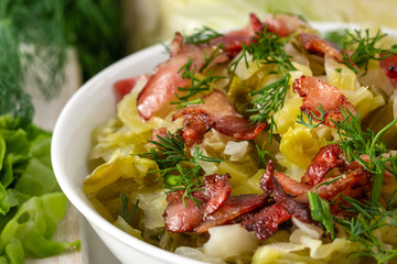 Stewed young cabbage with dill and grilled bacon.