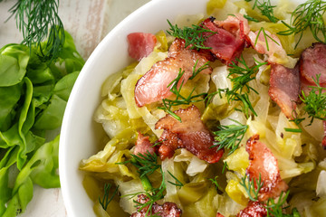 Stewed young cabbage with dill and grilled bacon.