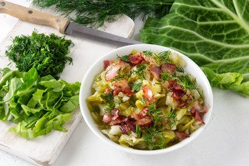 Stewed young cabbage with dill and grilled bacon.