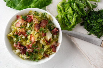 Stewed young cabbage with dill and grilled bacon.