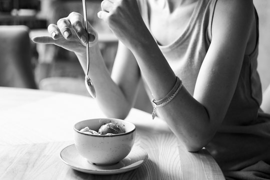 woman with ice cream at a table in a cafe, black and white photo