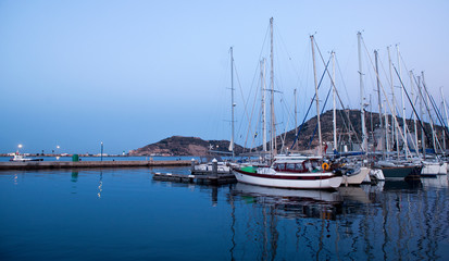 wooden surface pier and boats docked at dawn in the marina of Cartajena