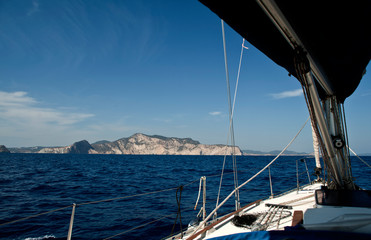 Fototapeta na wymiar bow of sailboat with open genoba the city of ibiza in the background
